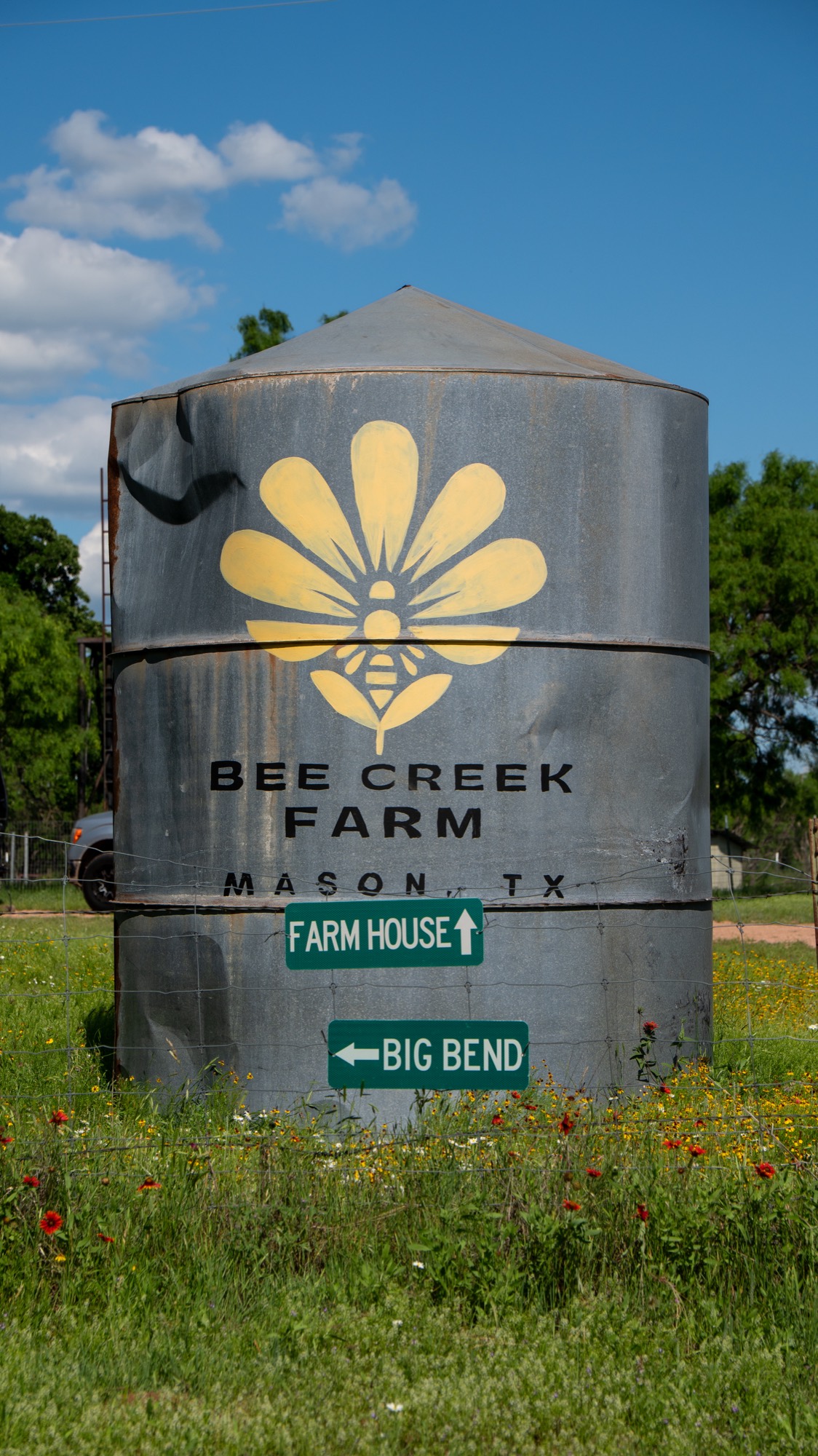 Bee Creek Farm hand-painted bee-and-flower mark on the silo